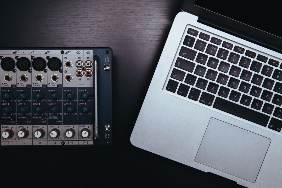 Close-up of audio mixer and laptop, essential for music production and sound editing.